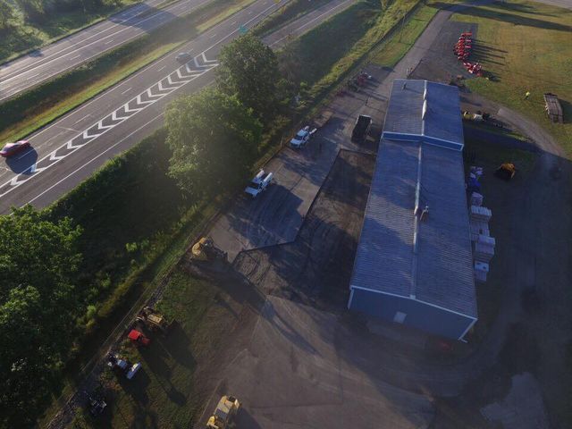 An aerial view of a large building next to a highway.