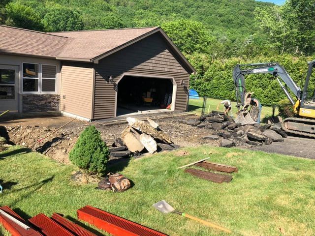 A house is being remodeled with a bulldozer in front of it.