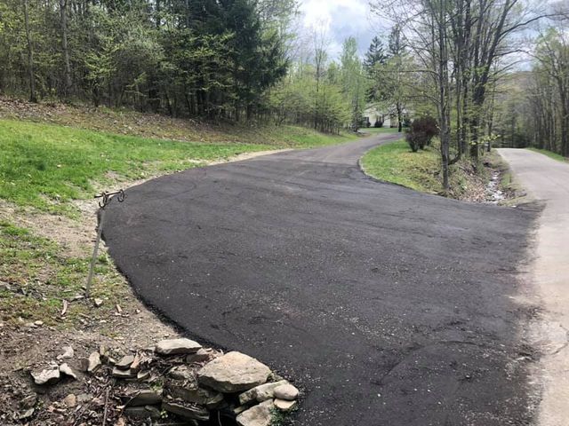 A curvy road going through a lush green forest.