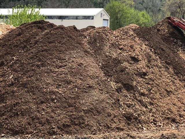 A large pile of dirt is sitting in front of a building.