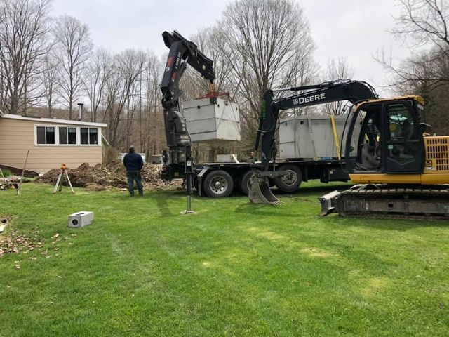 A crane is lifting a concrete block into a truck.