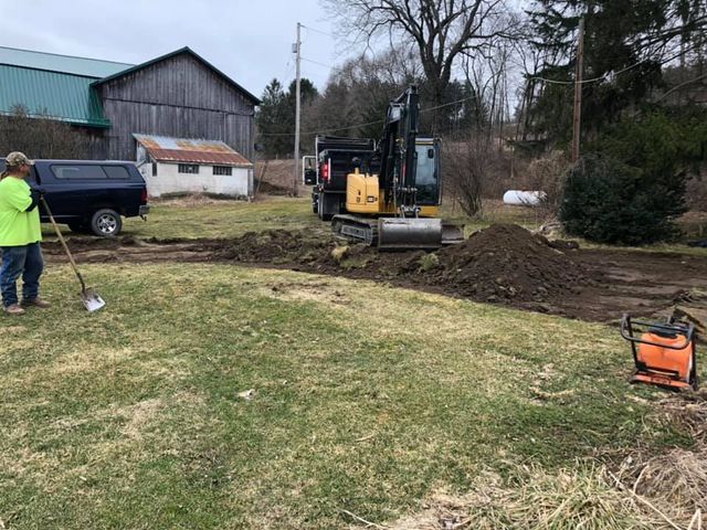A man is standing in front of a bulldozer in a field.