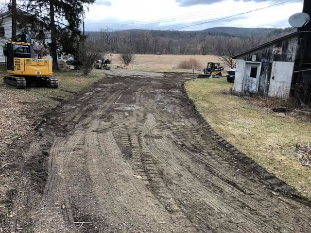 A dirt road with a tractor on the side of it.