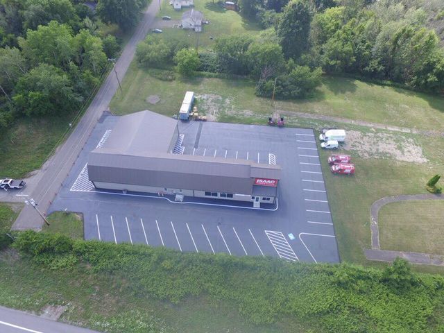 An aerial view of a building with a parking lot in front of it.