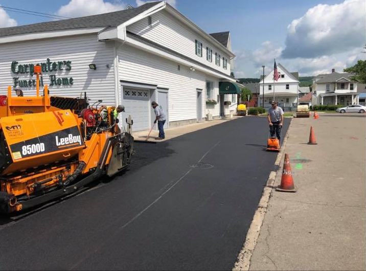 A road is being paved in front of a building.