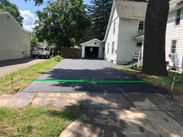 A car is parked in a driveway next to a house.