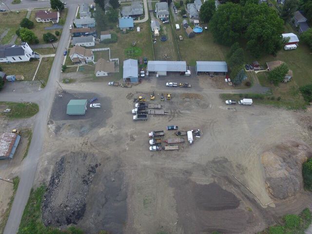 An aerial view of a residential area with a lot of buildings and trucks.