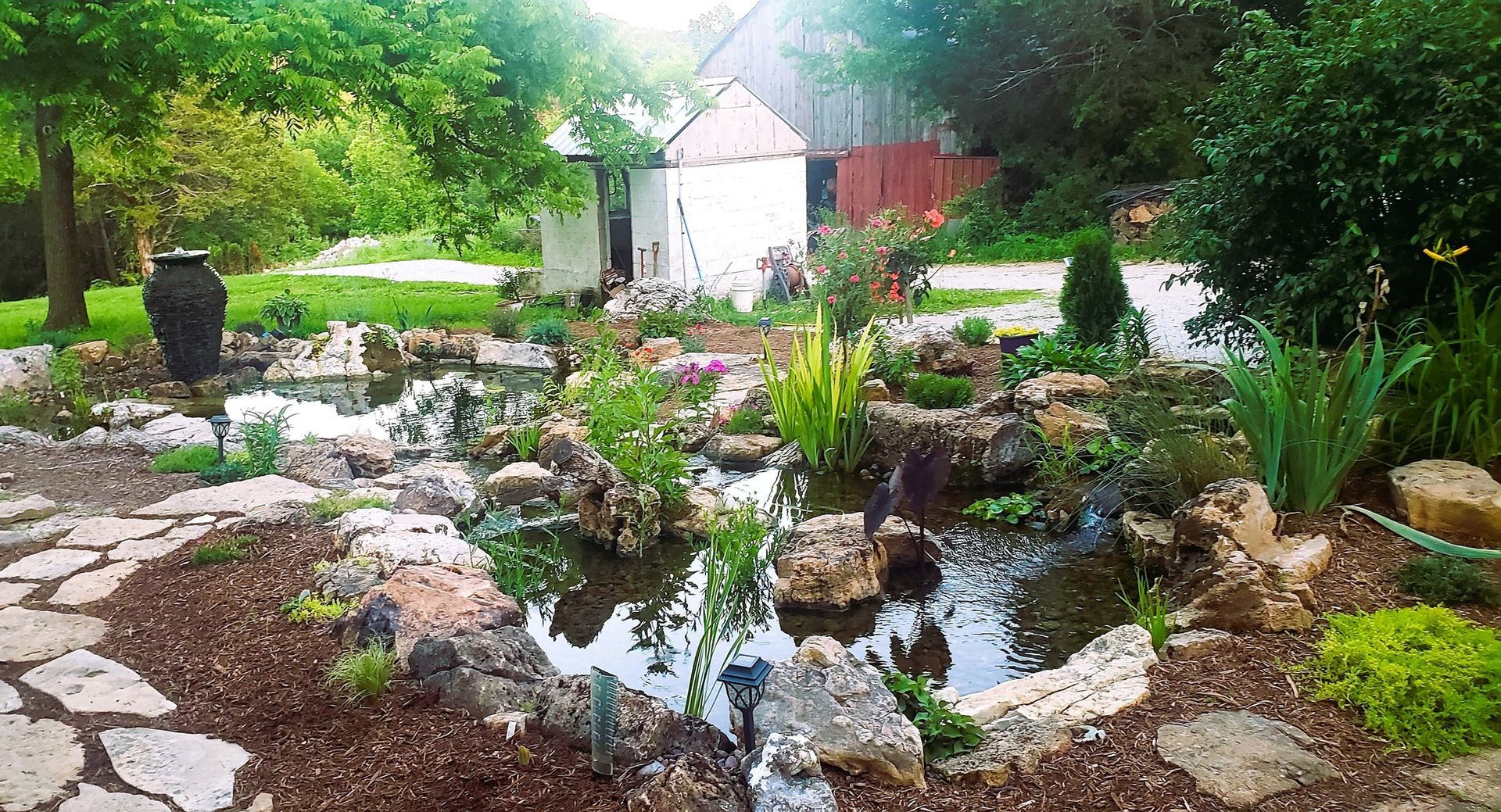 A pond surrounded by rocks and plants in a garden.