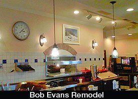 Restaurant interior remodel with light fixtures, counter, clock, and food prep area.