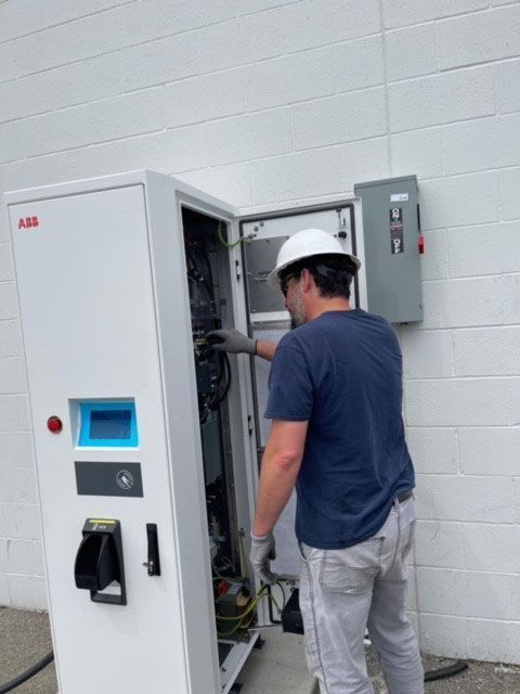 A technician checking on EV chargers
