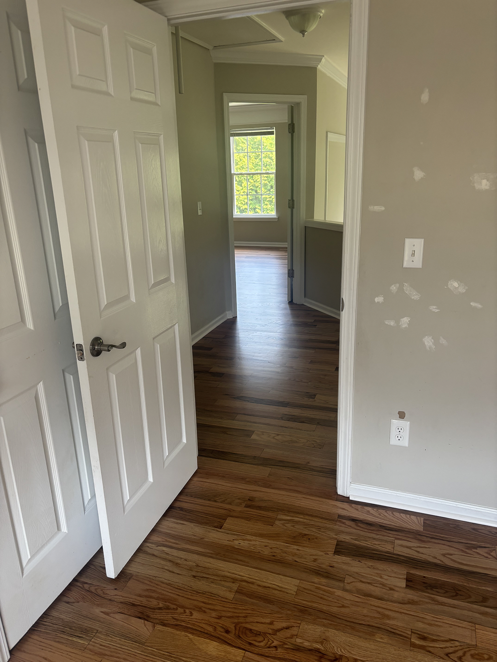 Bathroom renovation with white vanity, toilet, and door; black and white patterned floor; patterned wall.
