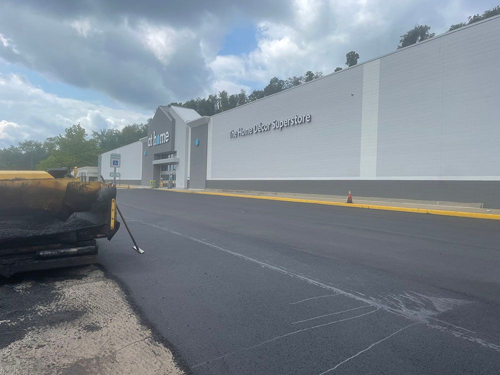 Asphalt paving in front of a gray building with the word 