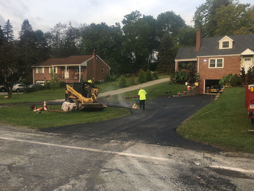Paving crew working on a driveway in a residential neighborhood.