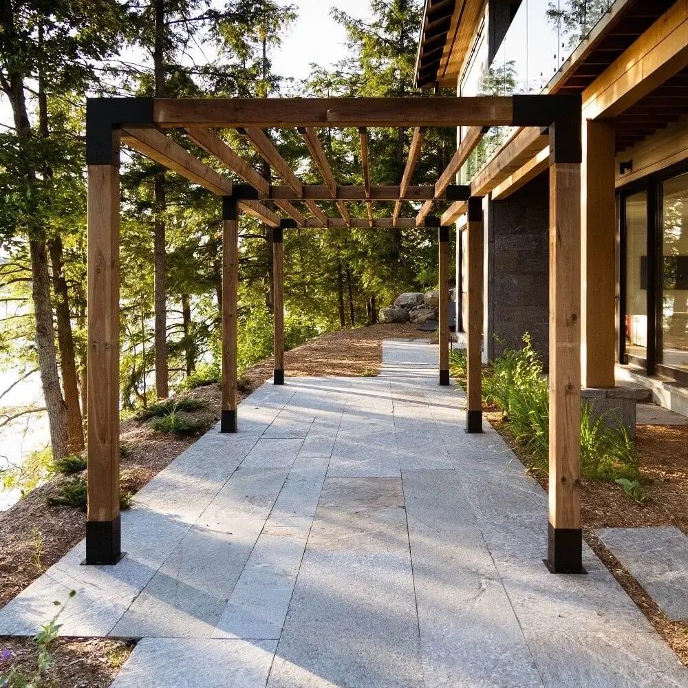 A wooden walkway leading to a house with trees in the background