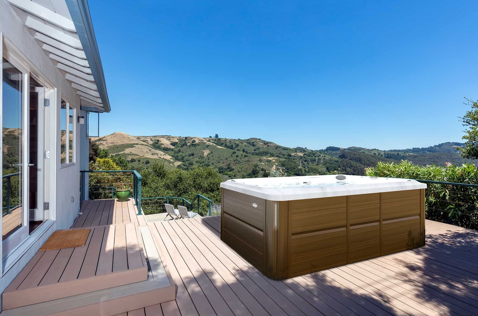 A hot tub is sitting on a wooden deck next to a house.