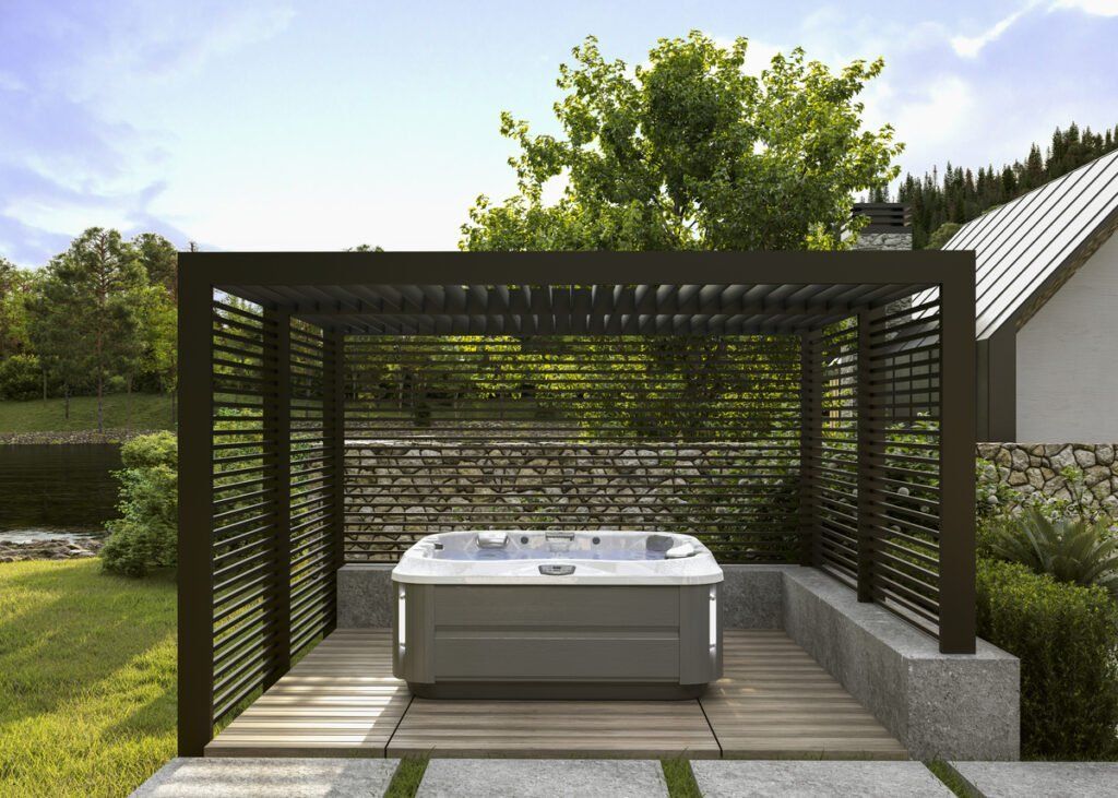 A hot tub is sitting under a pergola in a backyard.