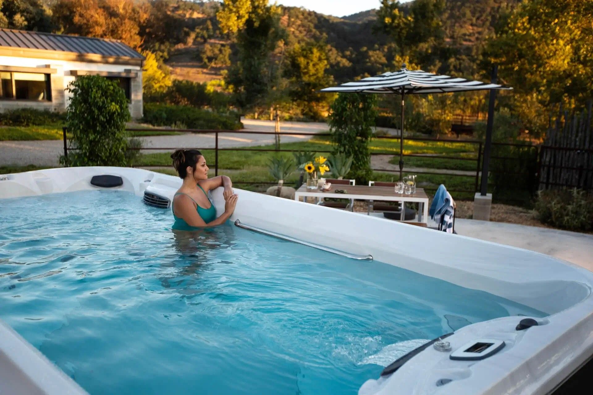 A woman is sitting in a large swimming pool.