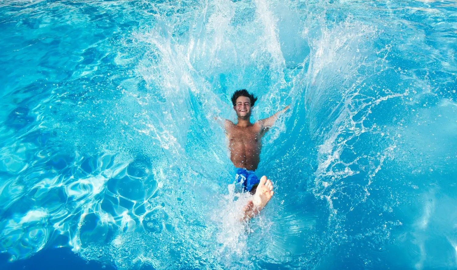 A man is jumping into a swimming pool.