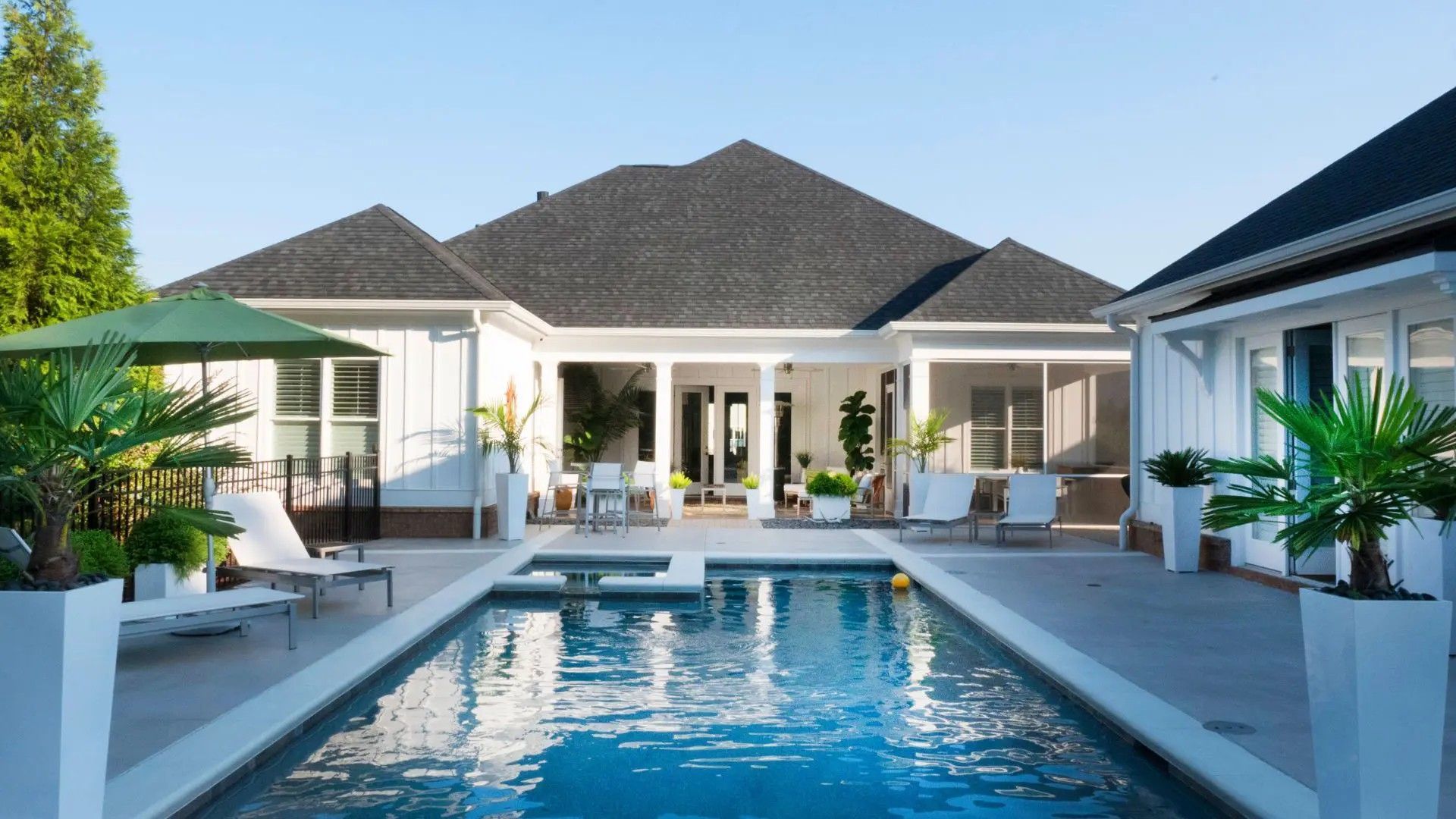 A large white house with a swimming pool in front of it