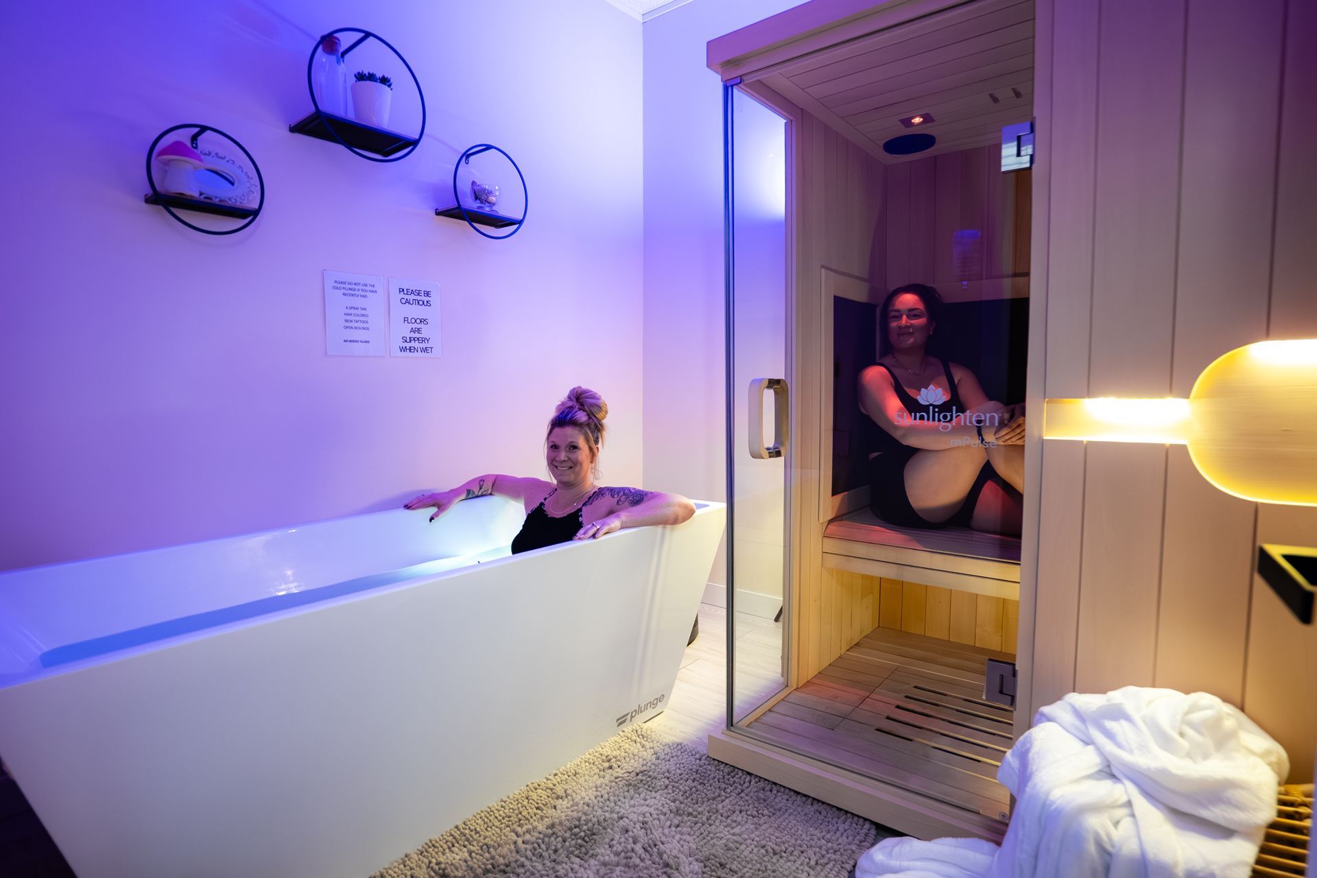 Woman in bathtub, another in sauna