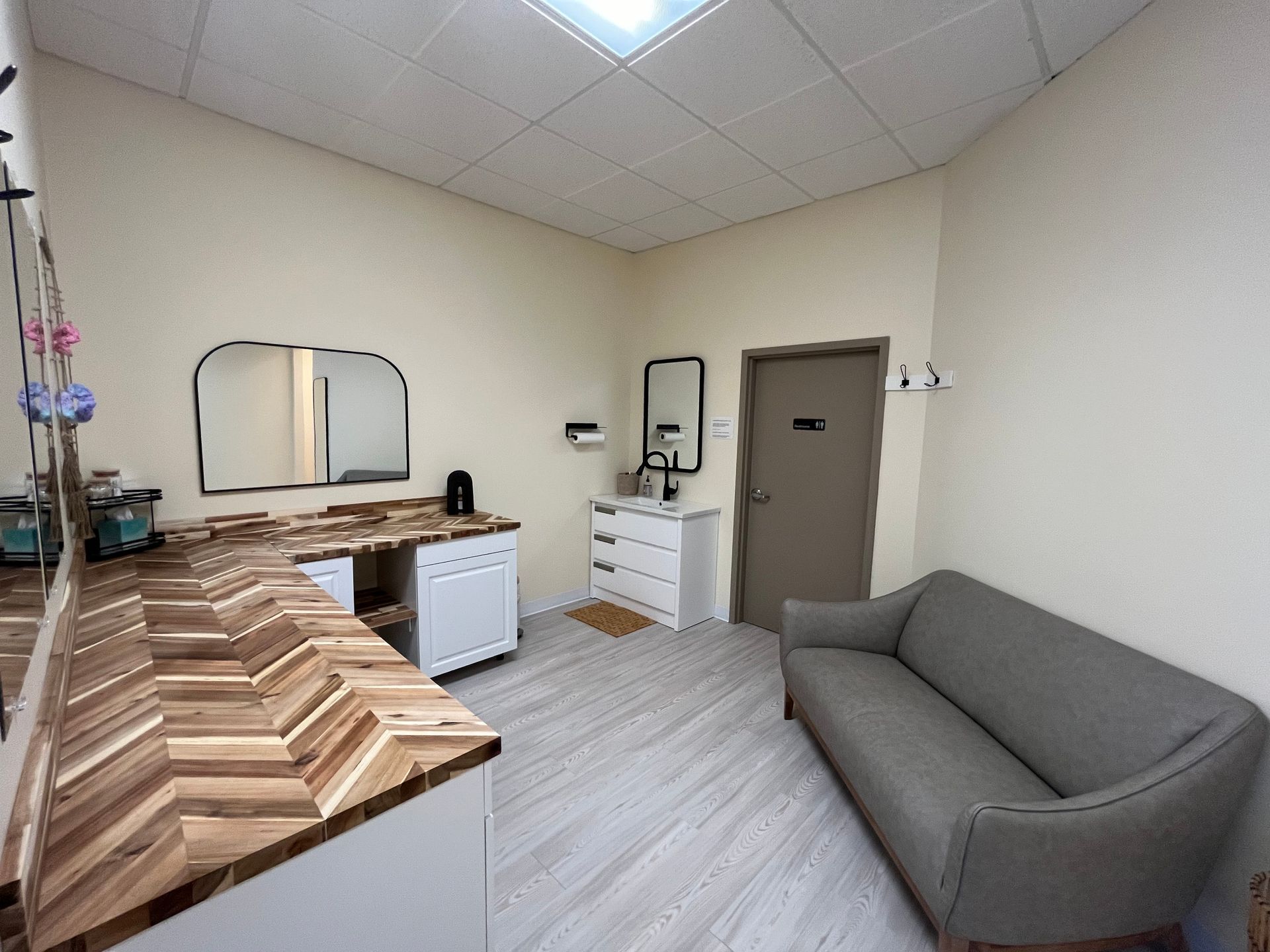 Small room with a sofa, vanity, and closed door