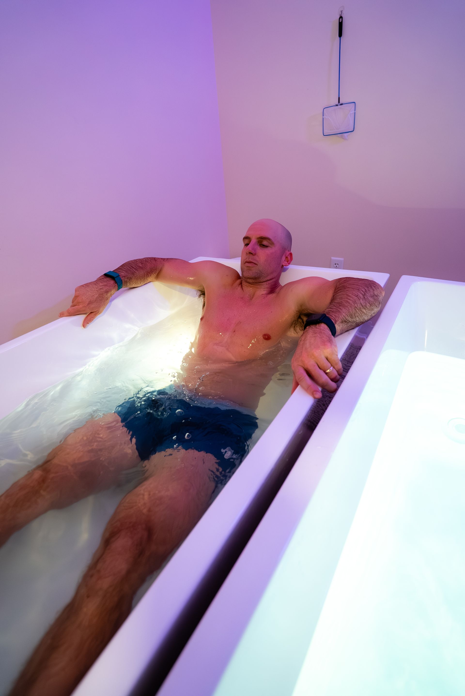 Man flotation tank, arms outstretched, relaxed