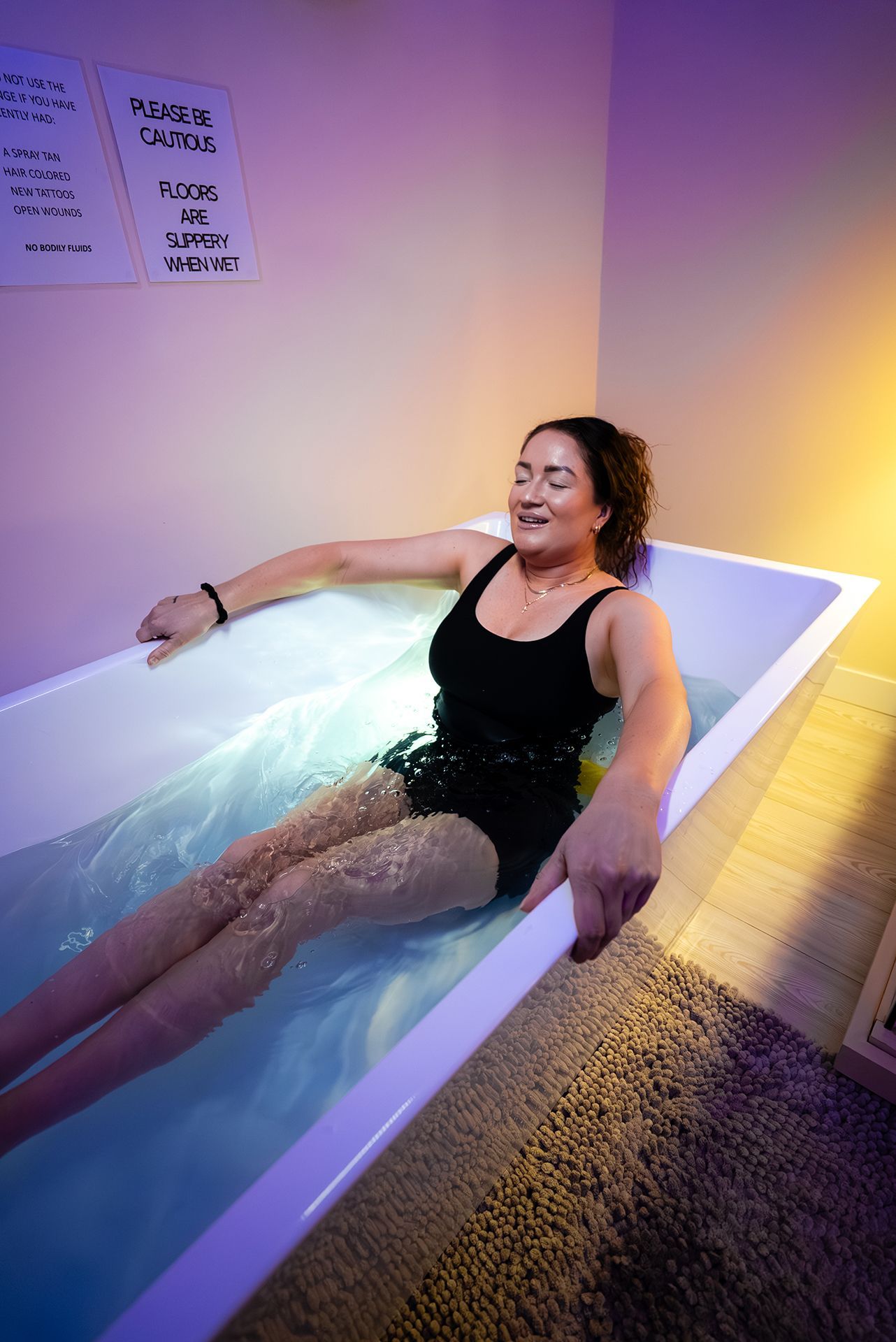 Woman relaxing in a white tub filled with water