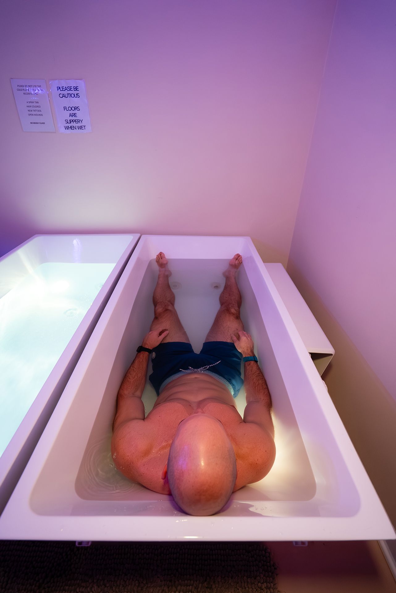 Man floating in a rectangular tank of water