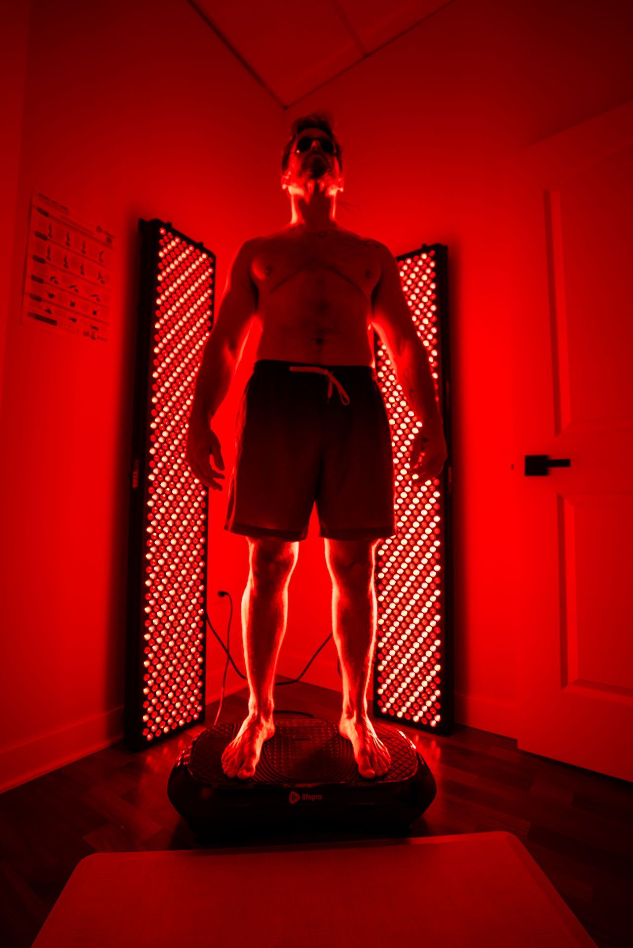Man stands between two red light therapy panels