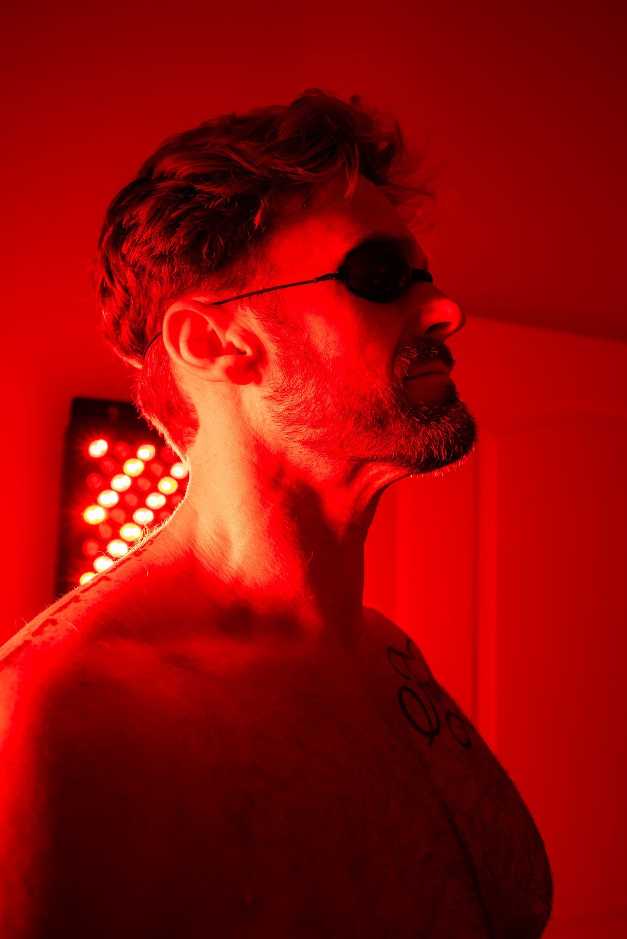 Man with eye protection, under red light