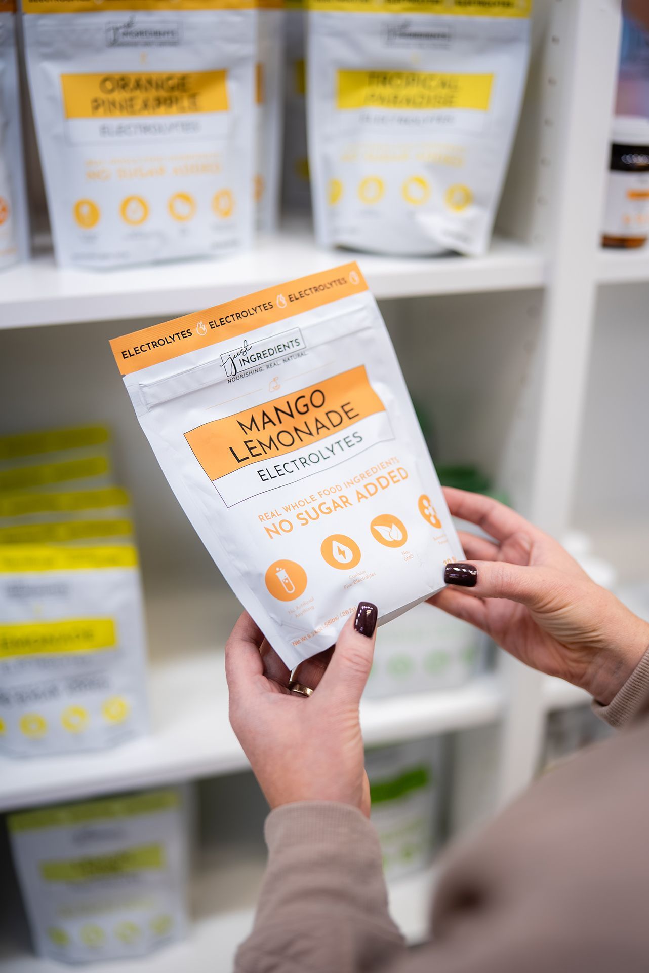 Person holding Mango Lemonade Electrolytes pouch in store