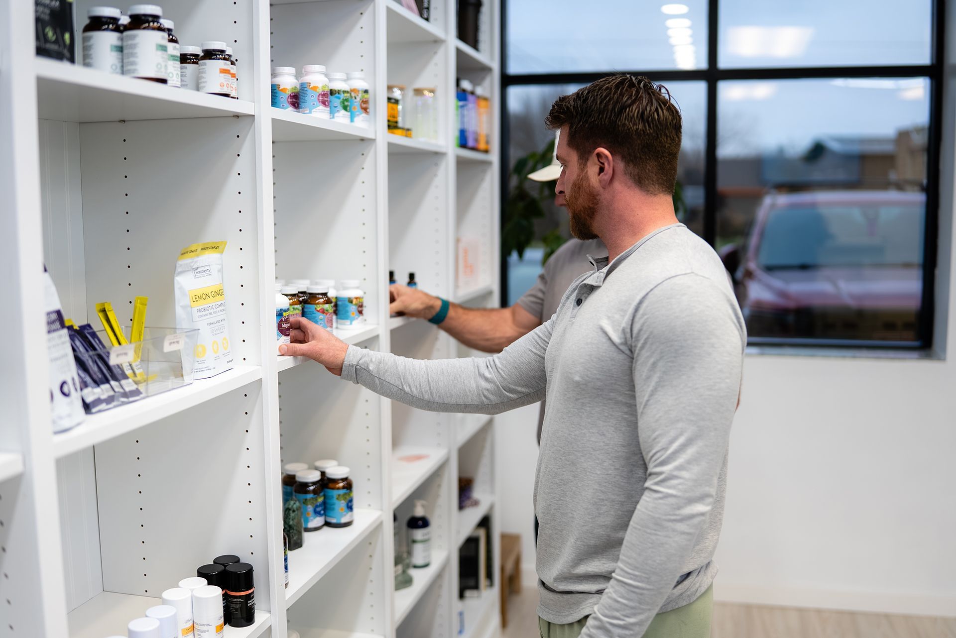 Two people browsing supplement shelves in a store