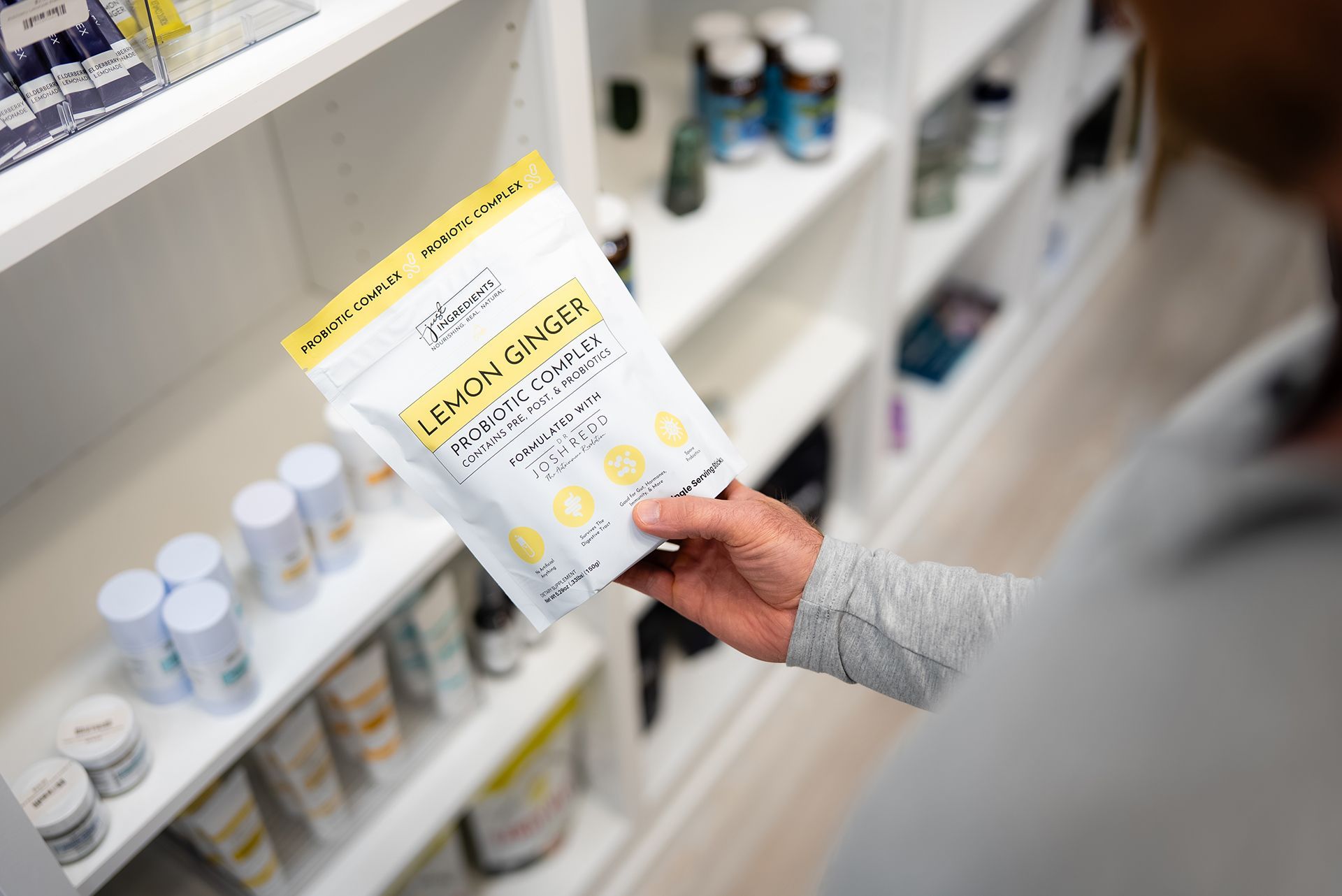 Person holding a Lemon Ginger Probiotic product package in a store