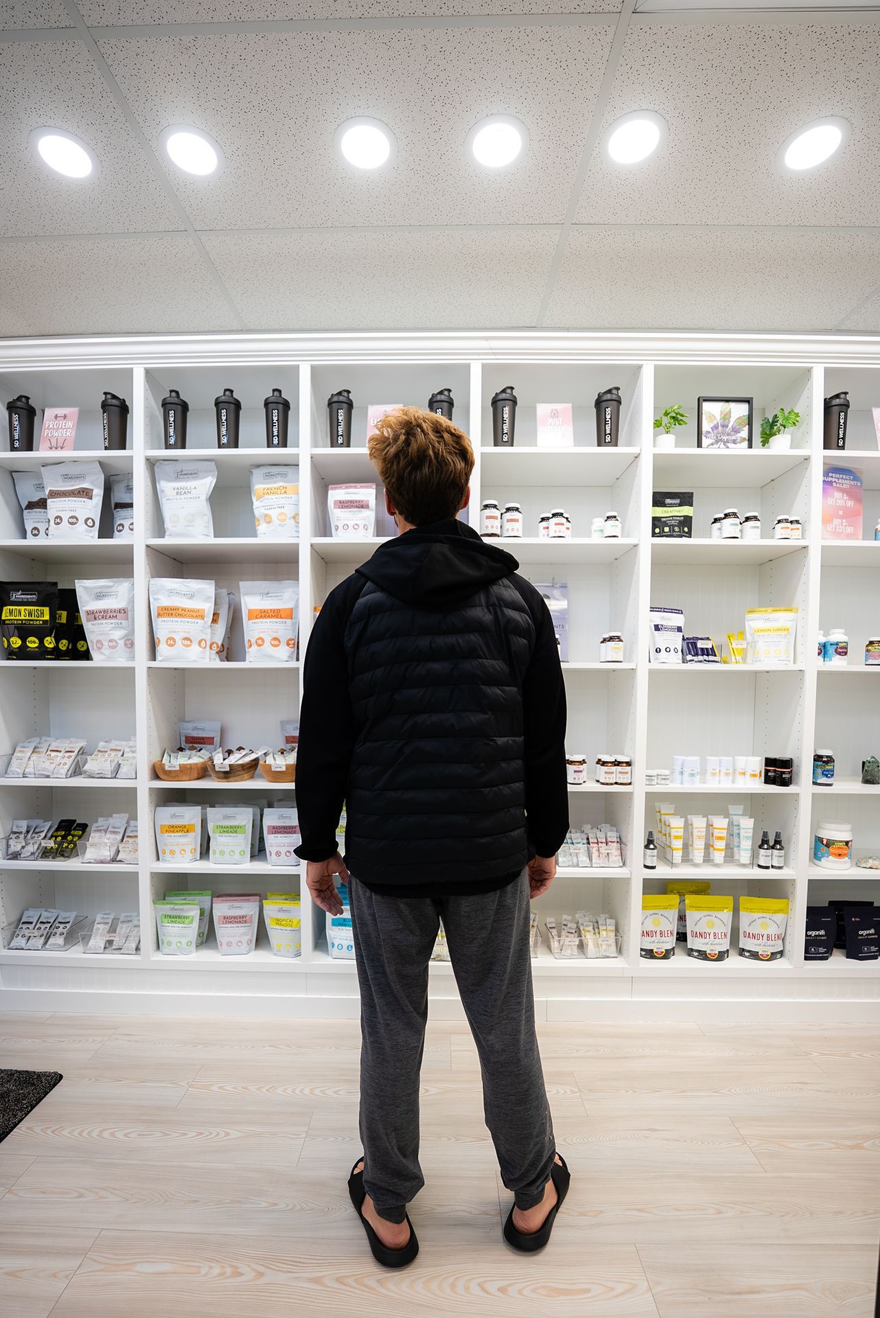 Person standing in front of shelves stocked with products