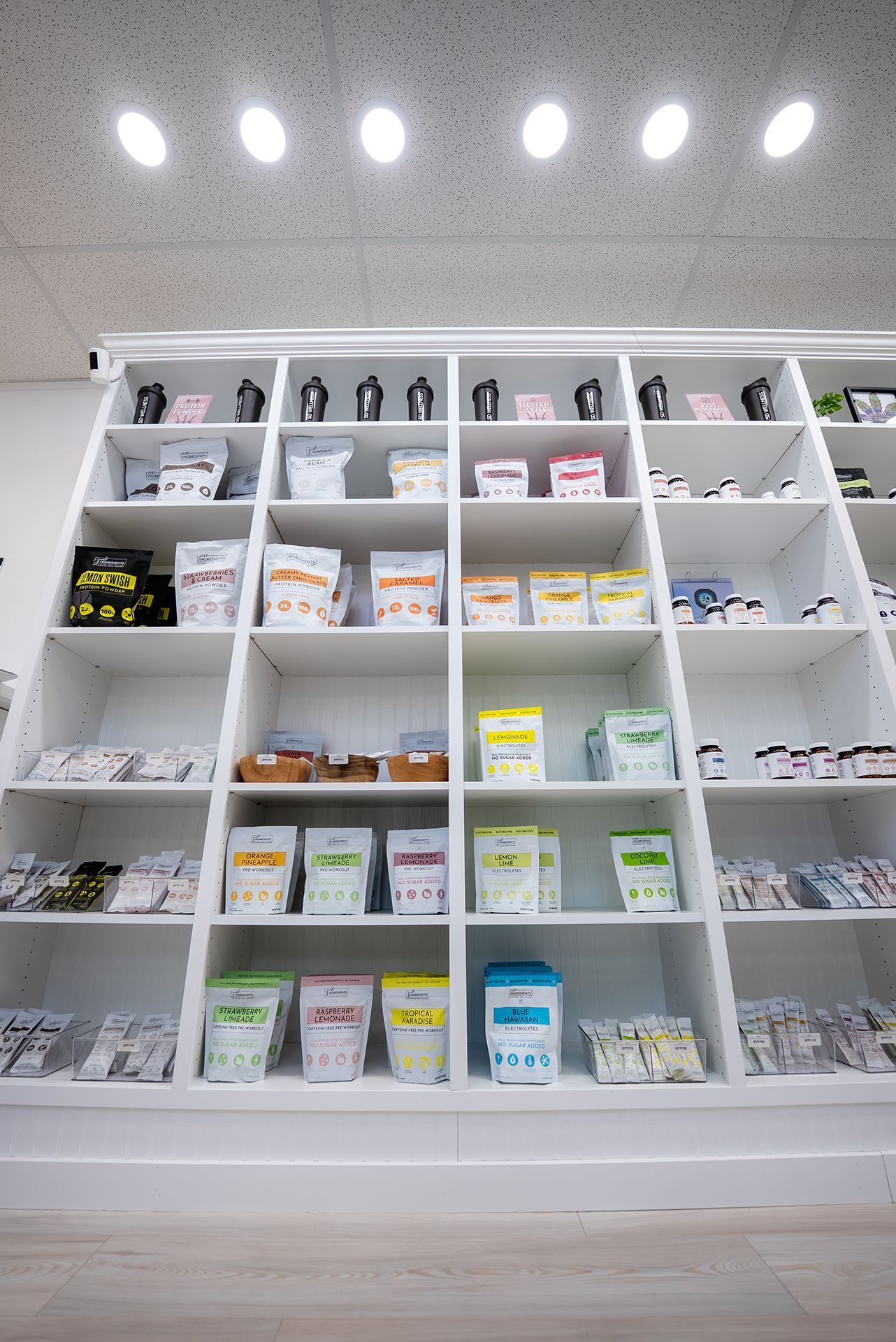 White shelving unit displaying various packaged products under bright ceiling lights