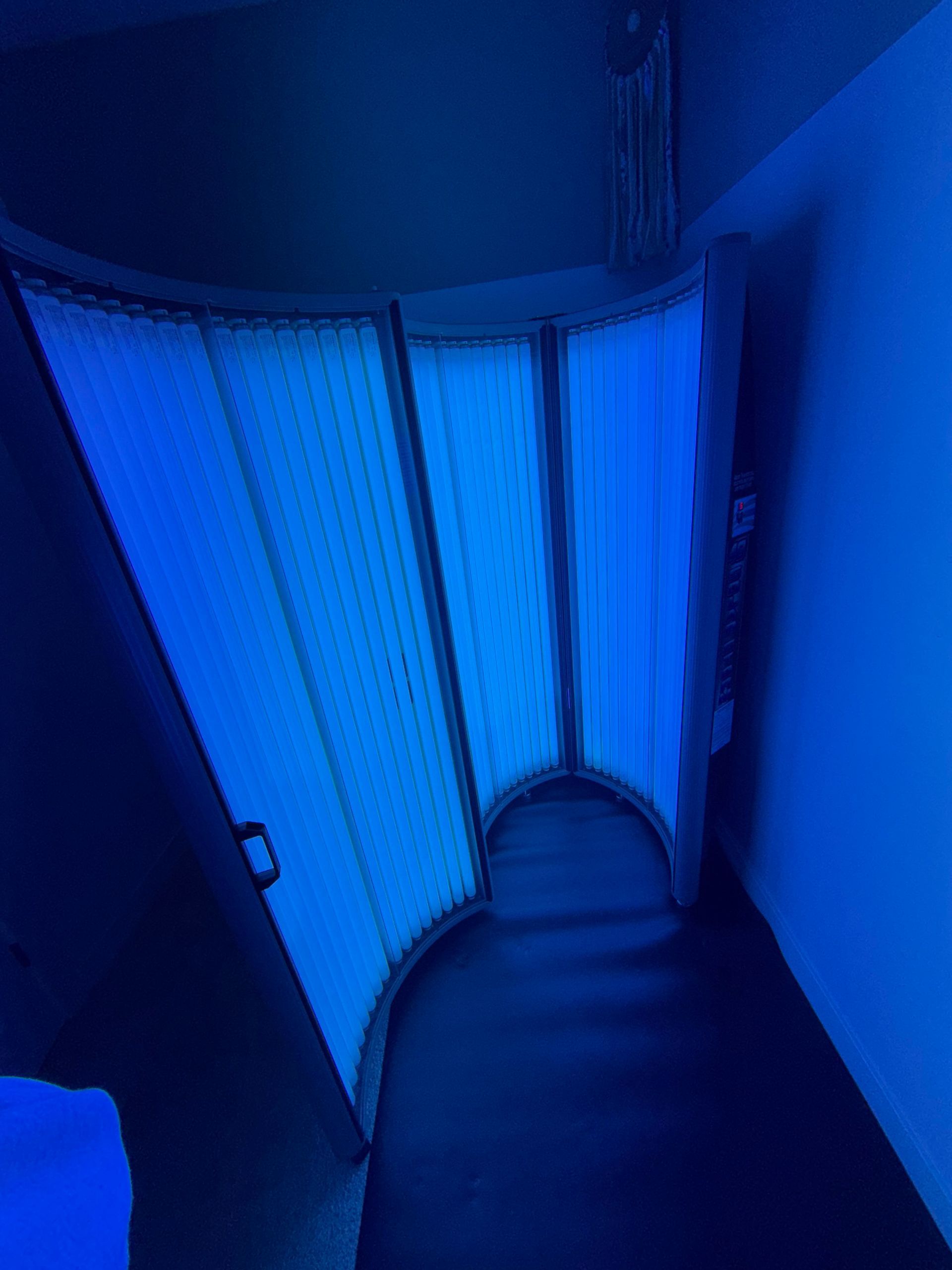 Blue-lit narrow hallway with curved partition walls and a dark floor