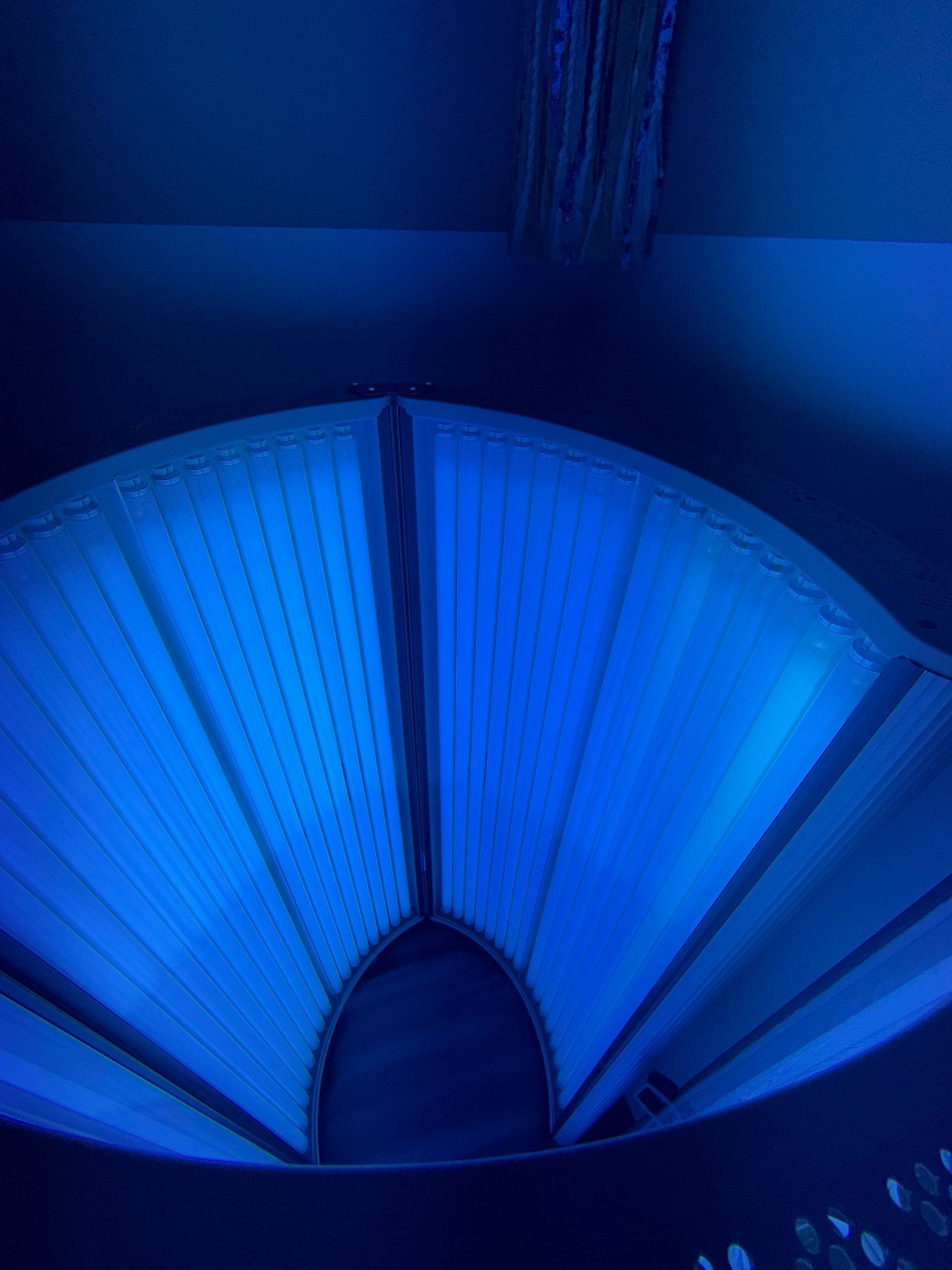 Blue-lit fan-shaped ceiling or wall installation with a dark center opening