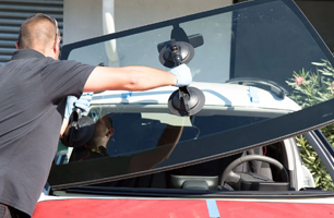A man is installing a windshield on a car