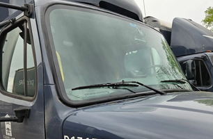 A close up of a truck windshield with wiper blades.