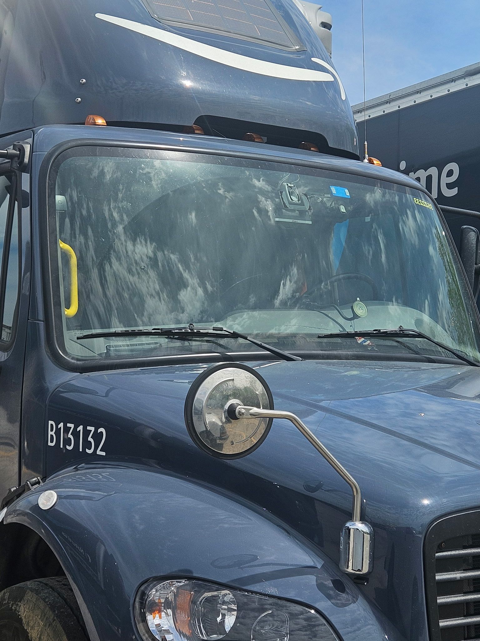 A blue semi truck with the license plate b12152 is parked in a parking lot.
