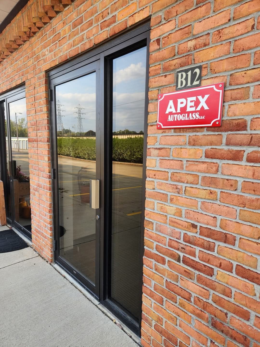 A brick building with a red sign that says apex on it.