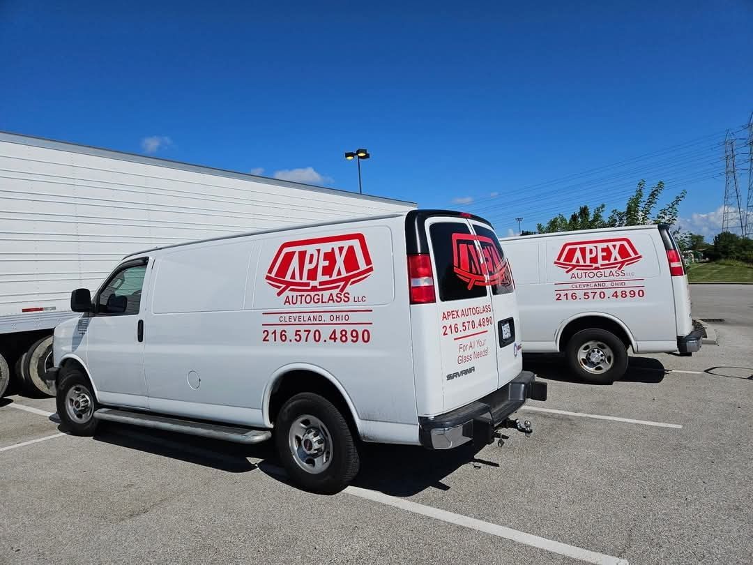 Two apex vans are parked in a parking lot.
