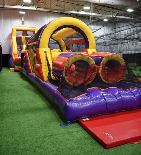 A large inflatable obstacle course is sitting on top of a red mat.