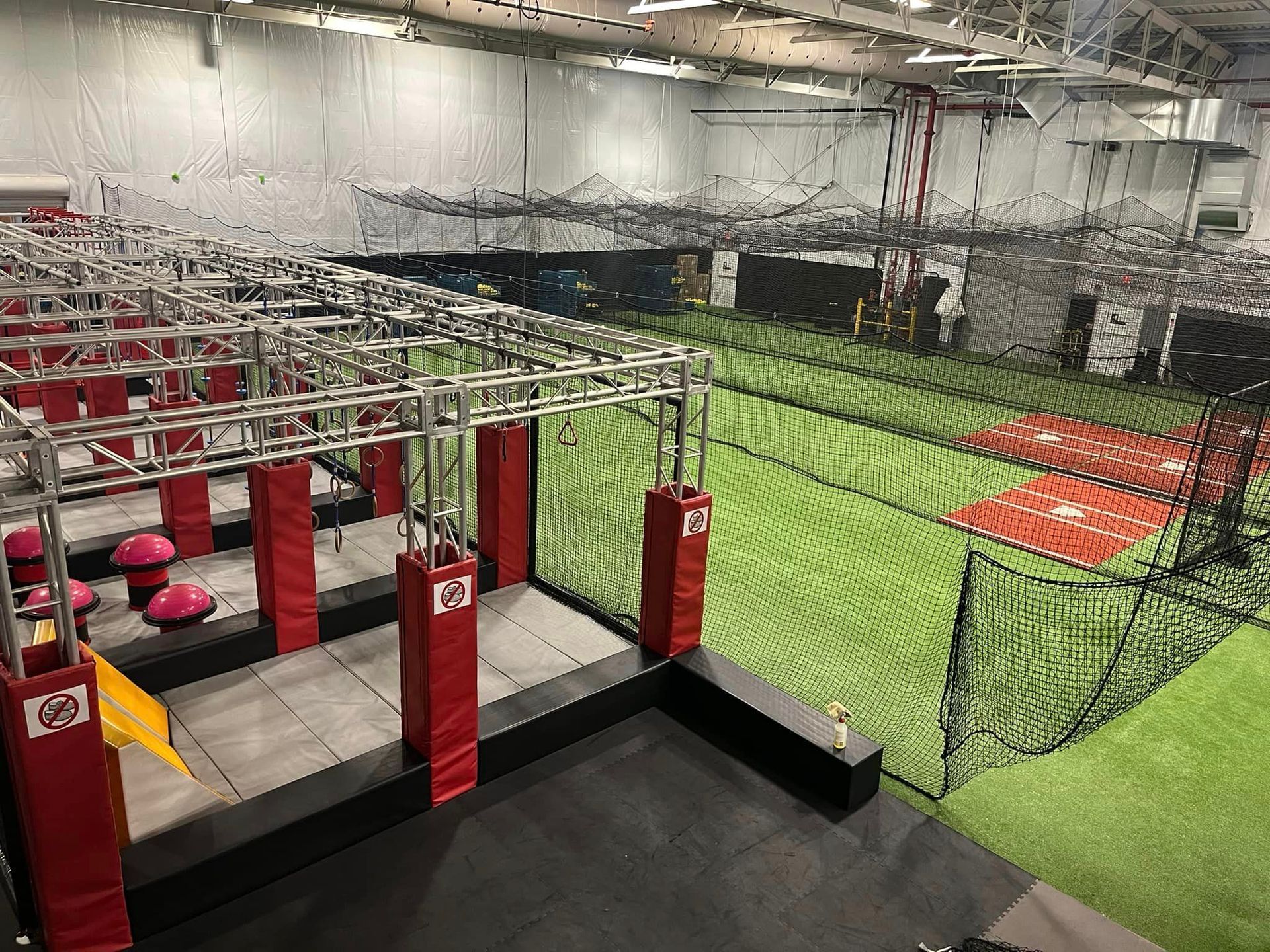 A large indoor gym with a baseball field in the background.