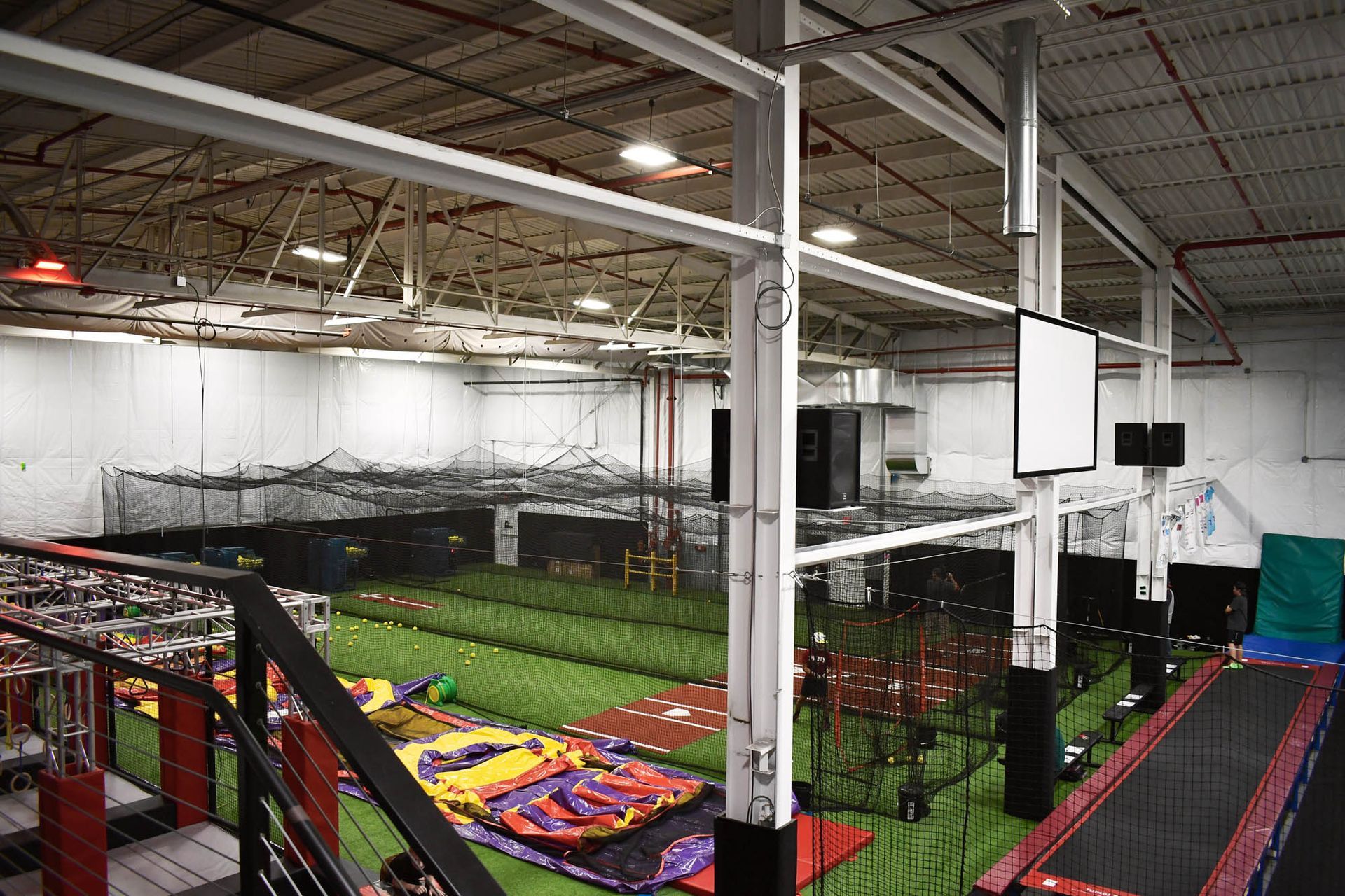 A large indoor trampoline park with a staircase leading up to it.