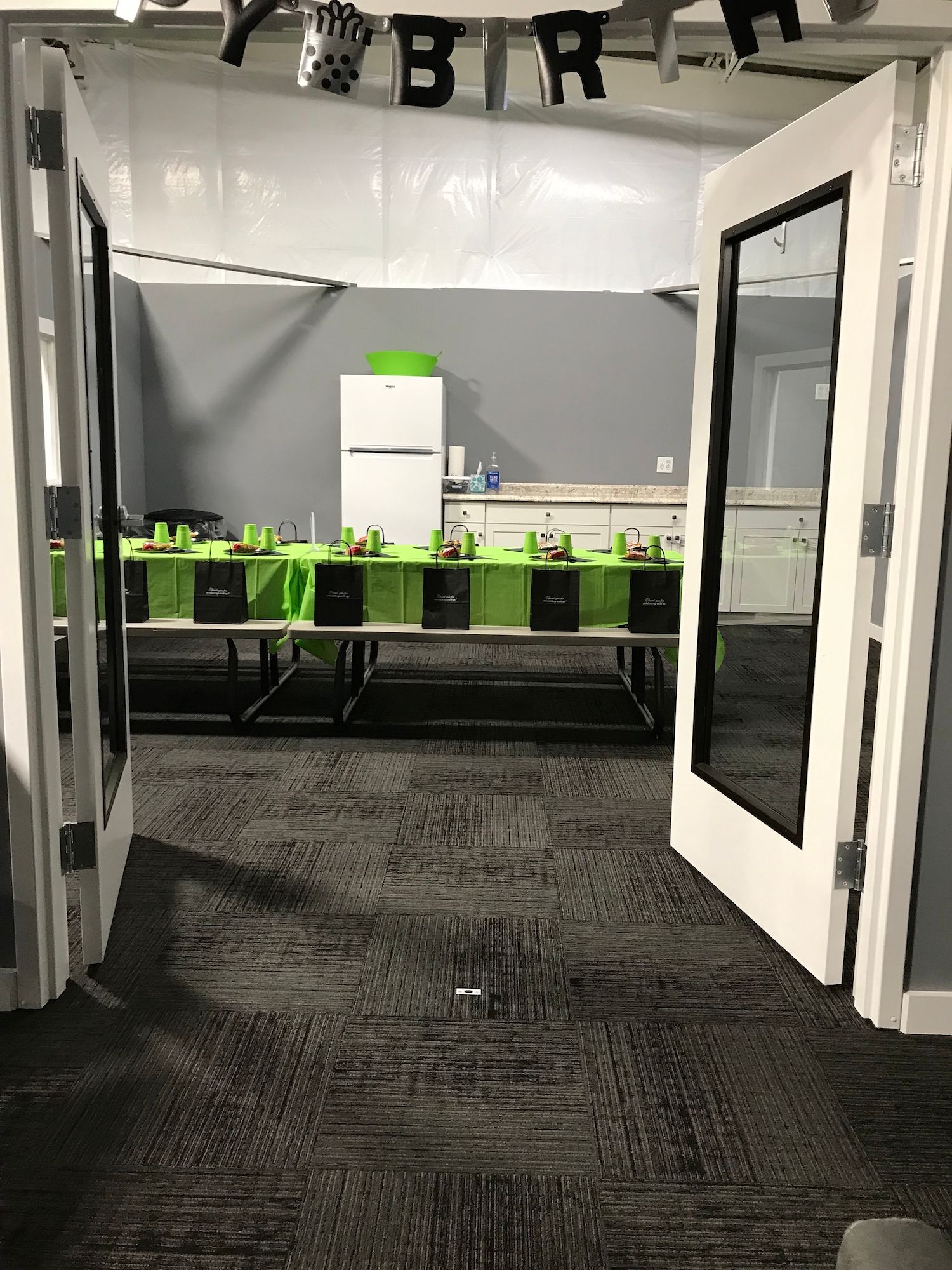 A room with tables and chairs set up for a birthday party.