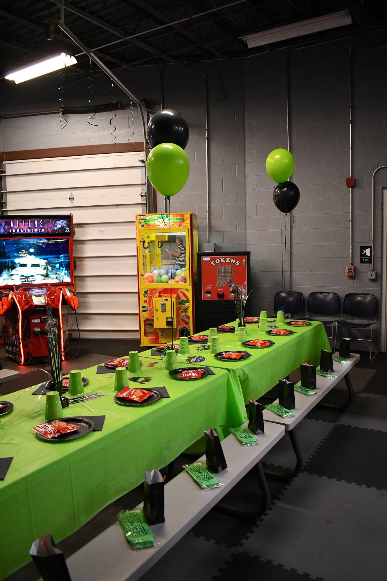 A long table with plates and cups on it is set up for a birthday party.