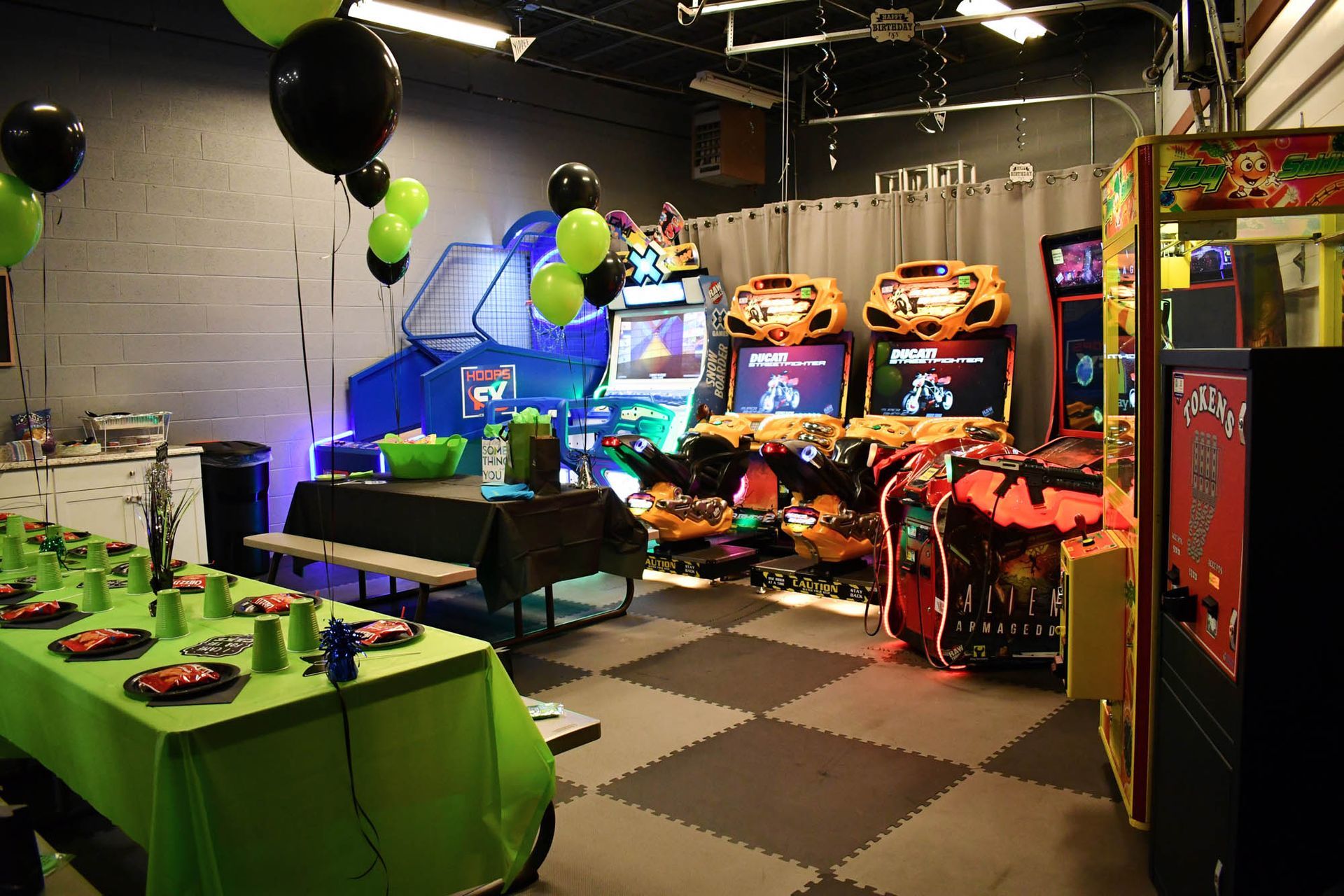 A room with tables and chairs and a bunch of arcade games