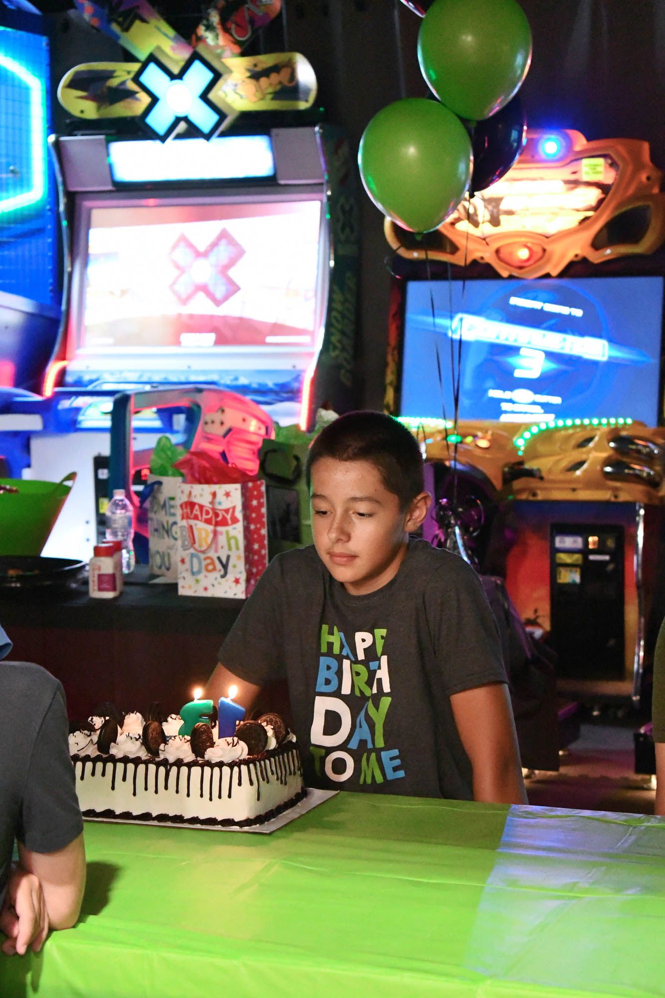 A young boy is sitting at a table with a birthday cake