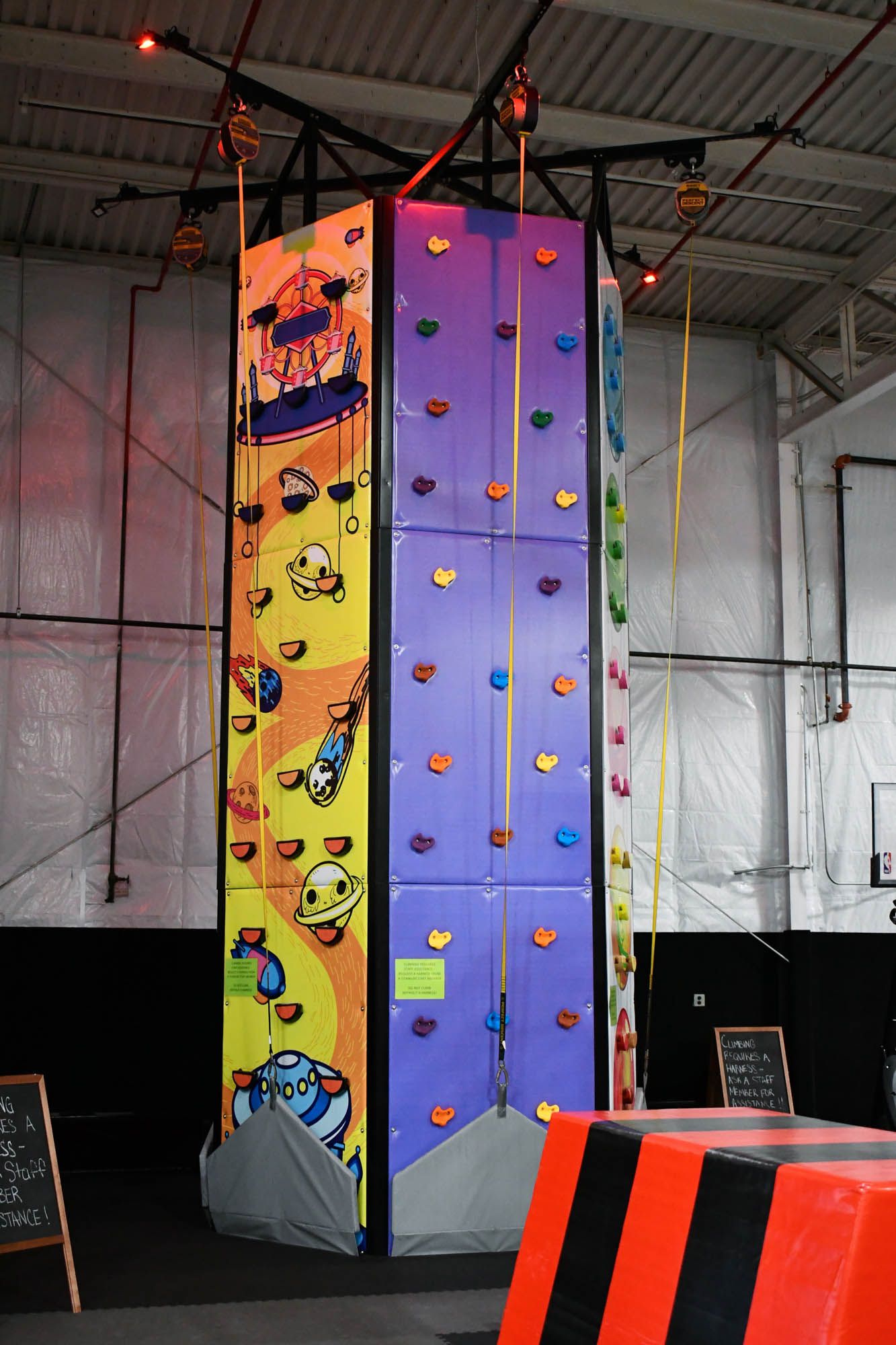 A large climbing wall with cartoon characters on it